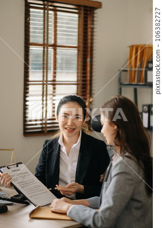 Judge gavel with scales of justice, Business and lawyer or counselor consulting and discussing contract papers with laptop and tablet at law firm in office. 106382727