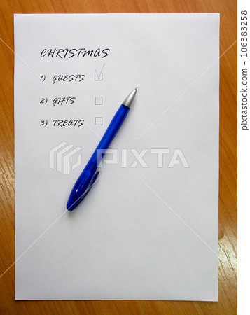 Checklist of new year holidays, text on a white sheet of paper next to a blue pen. 106383258