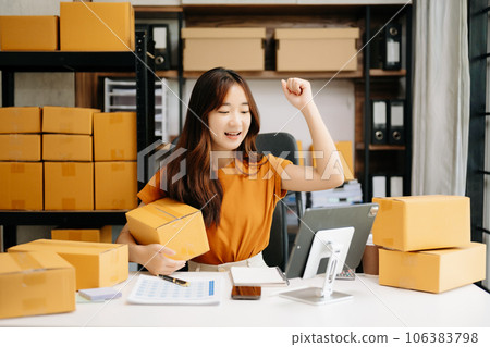 Startup small business SME, Entrepreneur owner woman using smartphone or tablet taking receive and checking online purchase shopping order to preparing pack product box. . Startup small business SME, Entrepreneur owner woman using smartphone or tablet taking receive and checking online purchase shopping order to preparing pack product box. . 106383798