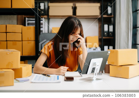 Young business owner woman prepare parcel box and standing check online orders for deliver to customer. woman is stressed, bored, and overthinking from working 106383803