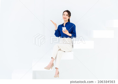 坐在樓梯上使用智能手機的女商人 106384563