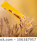 Cereal bar with chocolate and banana, yellow packaging. Against the background of wheat 106387957