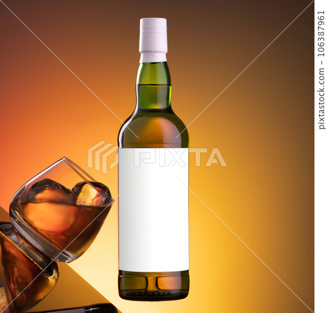 Bottle of whiskey on an orange background, glass with ice on glass, in the air Bottle of whiskey on an orange background, glass with ice on glass, in the air 106387961