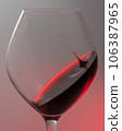 A falling drop of red wine in a glass, close-up. 106387965