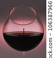A falling drop of red wine in a glass, close-up. 106387966