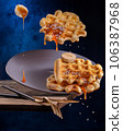 Viennese waffles with caramel and bananas fall off the edge of the table 106387968