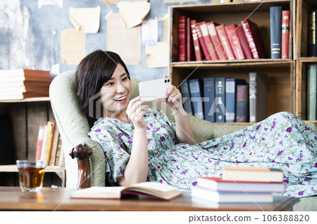 Woman watching a movie on her smartphone 106388820