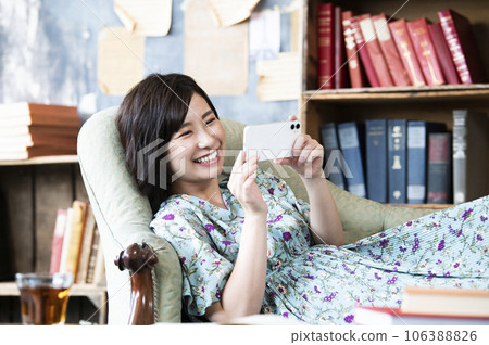 Woman watching a movie on her smartphone 106388826