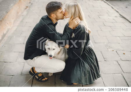 Man and woman happy together. Urban setting, husky dog. Man and woman happy together. Urban setting, husky dog. 106389448