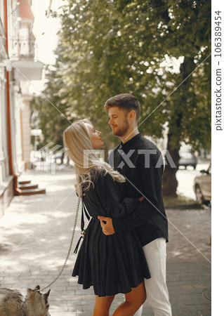 Man and woman happy together. Urban setting, husky dog. Man and woman happy together. Urban setting, husky dog. 106389454