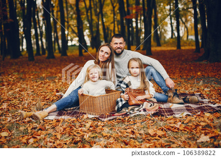 Family in a autumn park. Woman in a red sweater. Cute childrens with parents 106389822