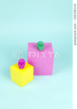 brightly colored plastic skulls on pink and yellow cubes 106390142