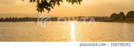 Lake schwarzl sunset panorama schwarzlsee near the styrian capitol graz in austria. View at surrounding mountains. Lake schwarzl sunset panorama schwarzlsee near the styrian capitol graz in austria. View at surrounding mountains. 106390262