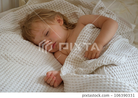 Peaceful adorable baby sleeping on his bed at home. Sleeping newborn baby concept. One year old baby girl sleeps peaceful at domestic room interior background. Serene dream. Cute Face Close Up Peaceful adorable baby sleeping on his bed at home. Sleeping newborn baby concept. One year old baby girl sleeps peaceful at domestic room interior background. Serene dream. Cute Face Close Up 106390331