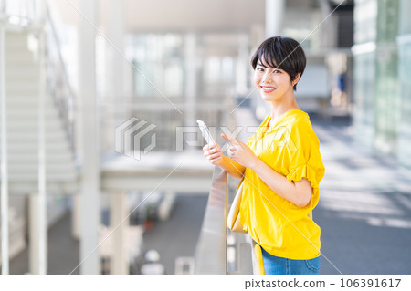 A young woman operating a smartphone. A young woman operating a smartphone. 106391617