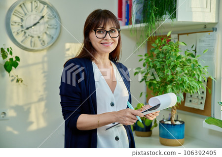 Portrait of specialist woman with clipboard in office Portrait of specialist woman with clipboard in office 106392405