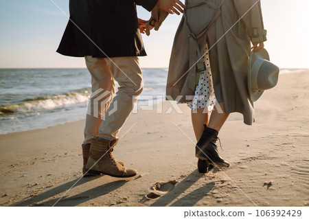 Stylish couple walking and hugging by the sea. Lovely hipster couple enjoying time together. Stylish couple walking and hugging by the sea. Lovely hipster couple enjoying time together. 106392429