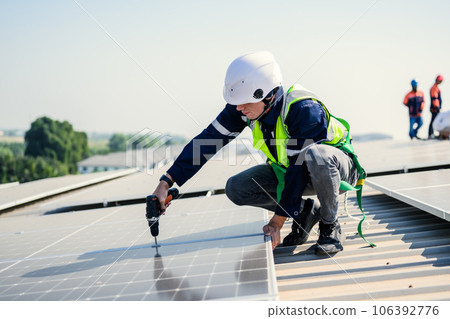 Engineers with safety helmet checking solar system at solar power farm Engineers with safety helmet checking solar system at solar power farm 106392776