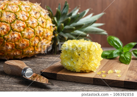 French goat cheese with pineapple pieces on a wooden cutting board, pineapple and basil French goat cheese with pineapple pieces on a wooden cutting board, pineapple and basil 106392858