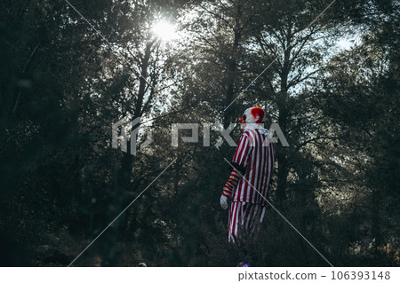 mad evil redhead clown walking by the woods 106393148