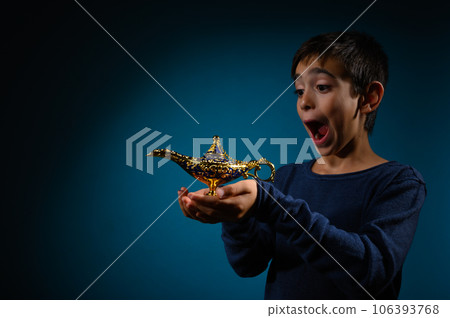 Amazed child with magic Aladin lamp in hand Amazed child with magic Aladin lamp in hand 106393768