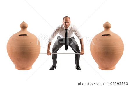 Powerful and determined businessman trains with a barbell with piggy banks 106393780