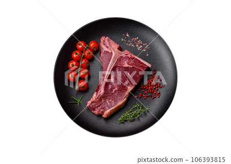 Raw juicy beef t-bone steak with salt, spices and herbs Raw juicy beef t-bone steak with salt, spices and herbs 106393815