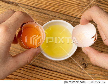 Broken Egg in Hand, Raw Yolk and White Separation, Cracked Brown Shell, Fresh Broken Organic Chicken Eggs Broken Egg in Hand, Raw Yolk and White Separation, Cracked Brown Shell, Fresh Broken Organic Chicken Eggs 106395137