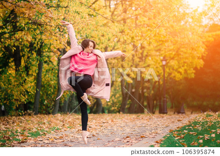Ballerina dancing in nature among autumn leaves. 106395874