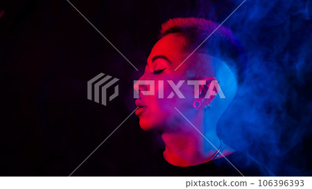 Profile Asian woman with short haircut smoking in neon light. Profile Asian woman with short haircut smoking in neon light. 106396393