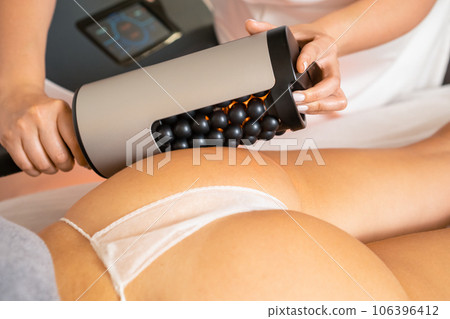 Vibration therapy massagers for body shape correction in spa salon. Body anti-cellulite process for women by professional beautician in salon 106396412