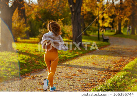 female in fitness clothes in park running 106396744