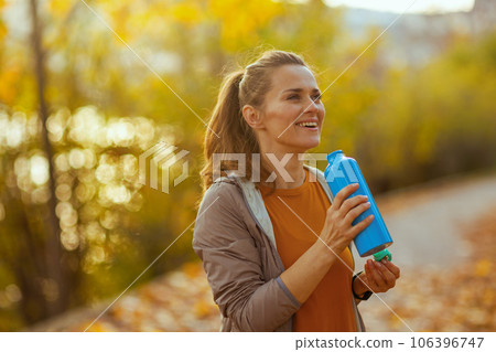 happy trendy woman in fitness clothes in park 106396747