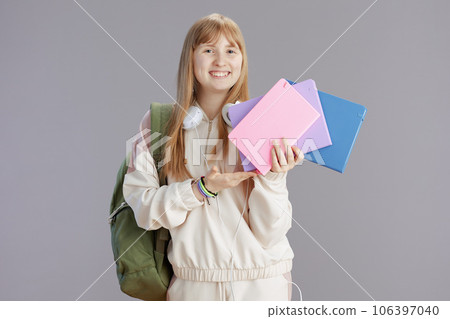 Portrait of happy modern teenage girl in beige tracksuit 106397040