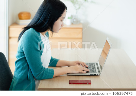 在筆記本電腦上做研究的年輕女子 106397475