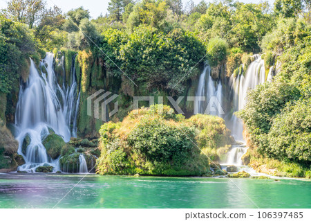 Kravica karst forest waterfall flows with lake in the foreground, Trebizat river, Bosnia and Herzegovina 106397485