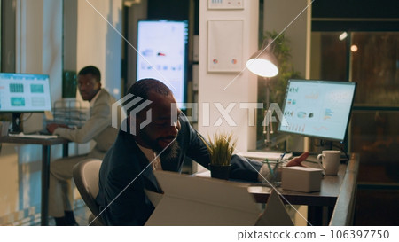 Businessman excited to finally quit stressful job, throwing desk belongings in box during last nightshift in office. Employee happy to leave workplace, being judged by disapproving coworker Businessman excited to finally quit stressful job, throwing desk belongings in box during last nightshift in office. Employee happy to leave workplace, being judged by disapproving coworker 106397750