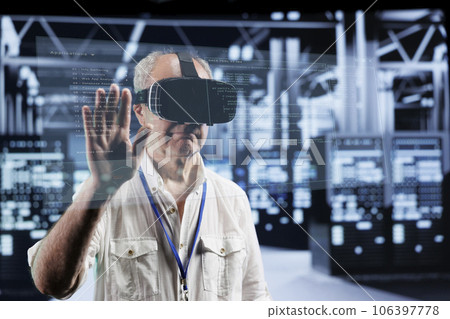 Octogenarian manager immersed in virtual reality at data center, doing equipment maintenance. Supervisor using VR headset to optimize server system performance, checking code lines Octogenarian manager immersed in virtual reality at data center, doing equipment maintenance. Supervisor using VR headset to optimize server system performance, checking code lines 106397778