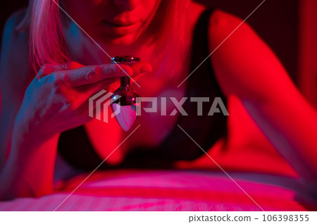 The blonde lies on the bed in red blue neon... - Stock Photo [106398355]