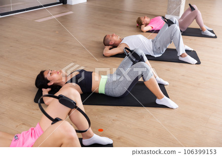 Active group of people performs an exercise with an isotonic ring Active group of people performs an exercise with an isotonic ring 106399153