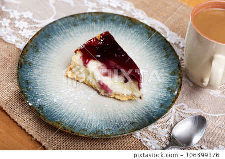 Pieces of cranberry cheesecake tart on wooden table. 106399176