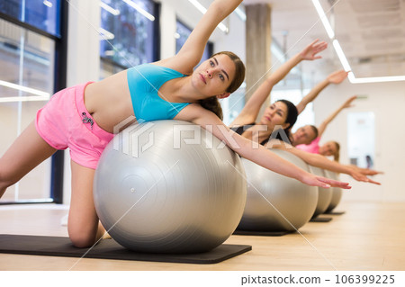 Young woman training pilates at group class Young woman training pilates at group class 106399225