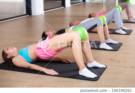 People doing hip bridge exercise with bender balls People doing hip bridge exercise with bender balls 106399262