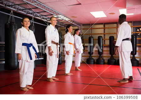 People in kimono standing in front of karate trainer 106399508