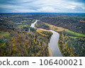 Above aerial shot of green pine forests and yellow foliage groves with beautiful texture of golden treetops. Beautiful fall season scenery in evening. Mountains in autumn colors in golden time 106400021