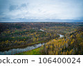 Above aerial shot of green pine forests and yellow foliage groves with beautiful texture of golden treetops. Beautiful fall season scenery in evening. Mountains in autumn colors in golden time 106400024