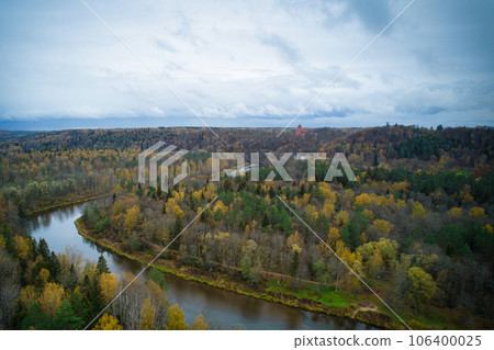 Above aerial shot of green pine forests and yellow foliage groves with beautiful texture of golden treetops. Beautiful fall season scenery in evening. Mountains in autumn colors in golden time Above aerial shot of green pine forests and yellow foliage groves with beautiful texture of golden treetops. Beautiful fall season scenery in evening. Mountains in autumn colors in golden time 106400025