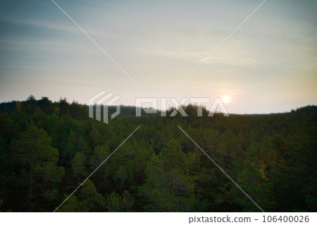 Above aerial shot of green pine forests and yellow foliage groves with beautiful texture of golden treetops. Beautiful fall season scenery in evening. Mountains in autumn colors in golden time Above aerial shot of green pine forests and yellow foliage groves with beautiful texture of golden treetops. Beautiful fall season scenery in evening. Mountains in autumn colors in golden time 106400026