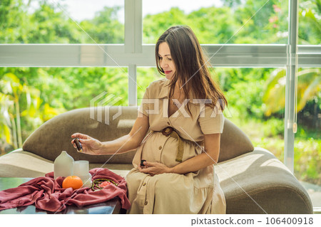 A serene moment captured as a pregnant woman after 40 embraces the soothing benefits of aroma oils and an aroma diffuser, enhancing her pregnancy journey with relaxation and tranquility 106400918