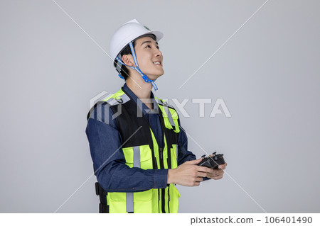 millennials and gen z, korean asian young man, site staff controlling a drone 106401490